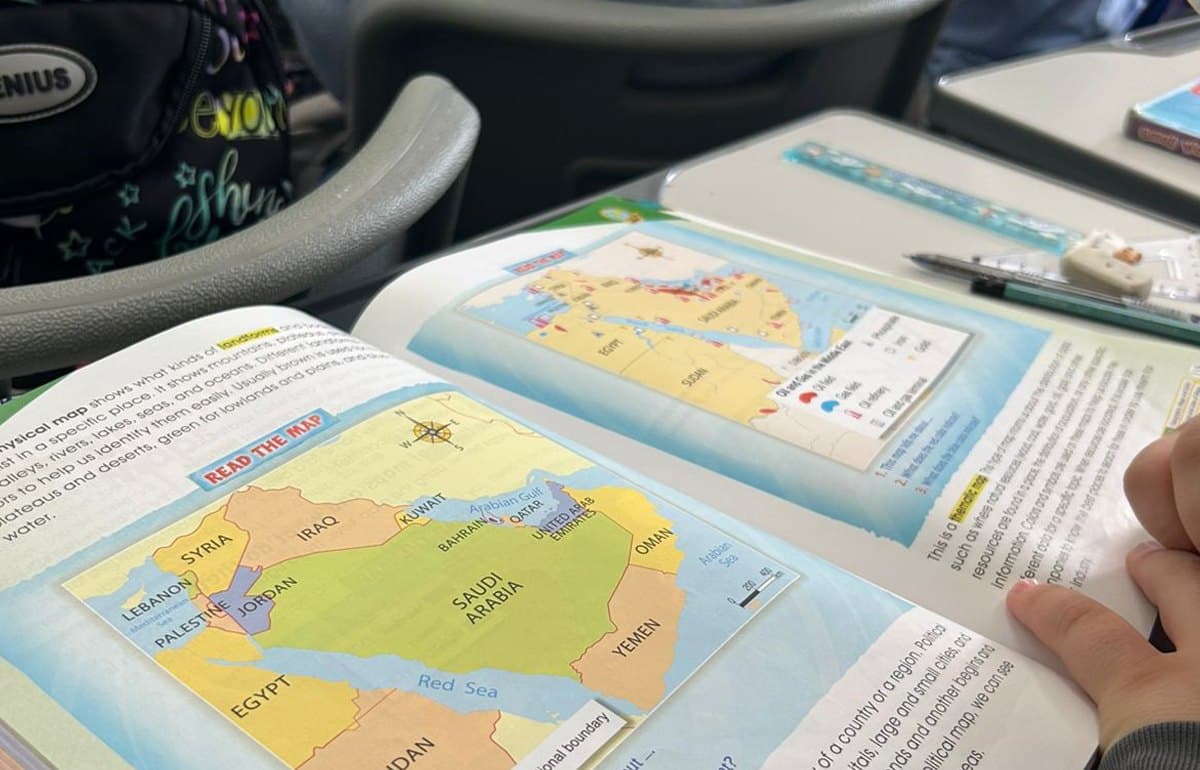 An open textbook with maps on a desk during a session